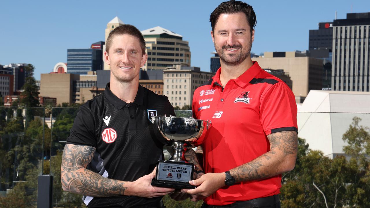 West Adelaide coach Adam Hartlett (right) with his brother and Port Adelaide SANFL coach Hamish Hartlett and the Russell Ebert Tribute Match trophy that the two clubs play for annually. Picture: David Mariuz/ SANFL