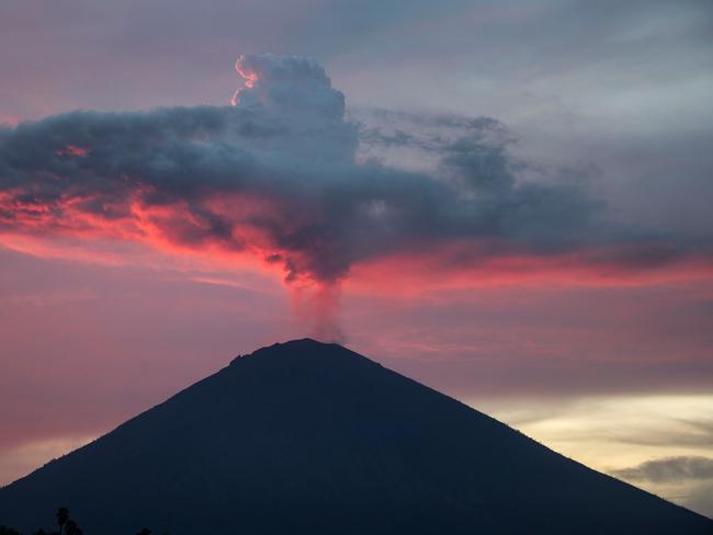 TOPSHOT - A general view shows Mount Agung from Amed beach in Karangasem on Indonesia's resort island of Bali on November 30, 2017. Thousands of foreign tourists were expected to leave Bali by plane on November 30 following a nearly three-day airport shutdown sparked by a rumbling volcano on the Indonesian holiday island. / AFP PHOTO / JUNI KRISWANTO