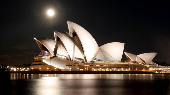 The full moon rises next to the Sydney Opera House in a deserted Circular Quay on Sunday. Picture: Damian Shaw