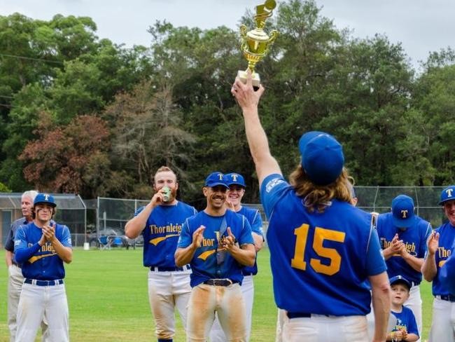 Captain/coach Ash Harrigan lifts the championship trophy.