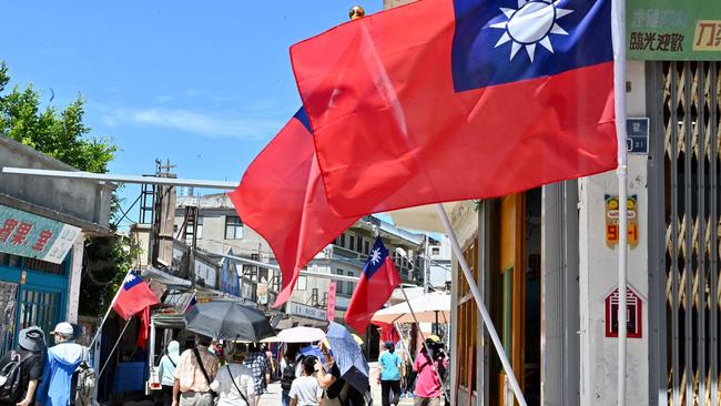 Taiwanese flags on a street lane as tourists walk past in Taiwan's Kinmen islands. Picture: AFP