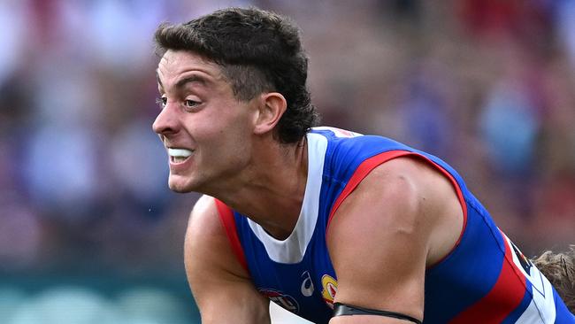 MELBOURNE, AUSTRALIA - MARCH 17: Nick Coffield of the Bulldogs handballs whilst being tackled during the round one AFL match between Melbourne Demons and Western Bulldogs at Melbourne Cricket Ground, on March 17, 2024, in Melbourne, Australia. (Photo by Quinn Rooney/Getty Images)