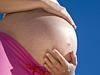 09/11/2010 NEWS: 09/11/2010 NEWS: Caucasian pregnant woman with hands on her belly against the blue sky. Pregnant belly . Sto...