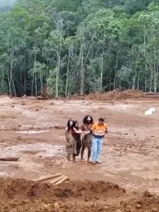 One of the workers can be seen holding the arms of the tribe members. Picture: Supplied