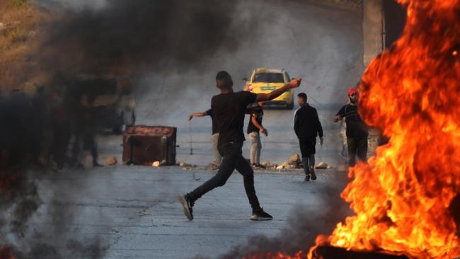 A Palestinian demonstrator throws rocks towards Israeli soldiers during clashes in Ramallah. Picture: AFP