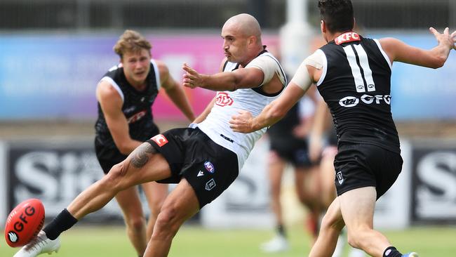 Sam Powell-Pepper gets a kick away as Tom Rockliff closes in.