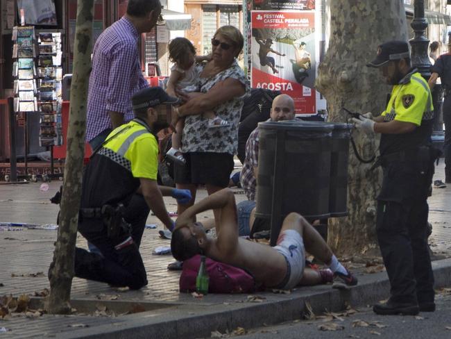 Police officers attend an injured man after a van crashed into pedestrians in Las Ramblas, downtown Barcelona. Picture: EPA/David Armengou