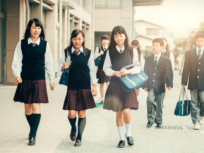 Teenage students in uniforms walking back to School