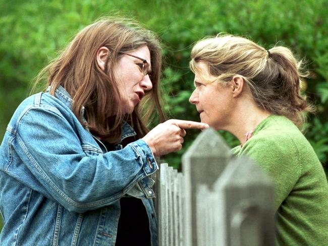 ## HAVE YOU /CHECKED COPYRIGHT /CLEARANCE ?? 03 Apr 2003: Two women arguing across a fence re: neighbourhood dispute. people quarrelling fences disputes neighbours generic profile pointing finger