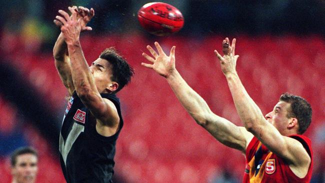 Victoria’s Matthew Lloyd (left) lets the wet ball slip through his fingers in front of SA defender Sean Wellman during the last true AFL State of Origin game between the states at the MCG in 1999. Picture: Graham Crouch