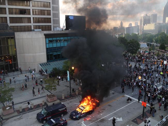 A police car burns after protesters marched to the Georgia State Capitol. Picture: Alyssa Pointer/Atlanta Journal-Constitution via AP