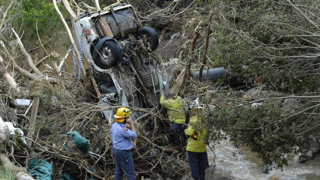 QFRS firefighters work to confirm that this vehicle found in Gowrie Creek days after the massive flood swept through Toowoomba contains no bodies, Friday, 14 January 2011. Toowoomba flash flood aftermath Photo Kevin Farmer / The Chronicle