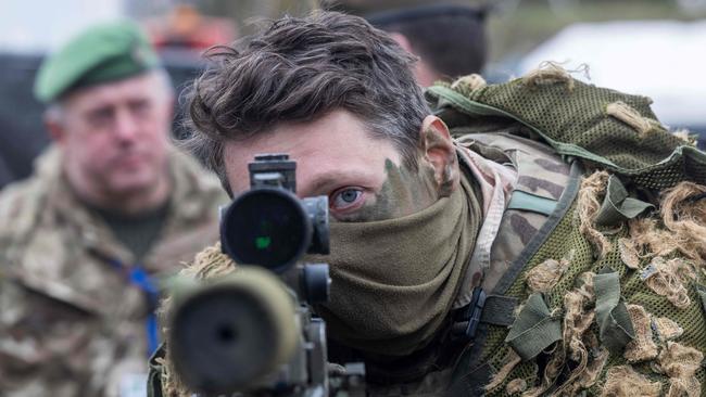 A British soldier looks into a telescopic sight as he holds his sniper rifle during the NATO DRAGON-24 military exercise in Korzeniewo, northern Poland, March 4, 2024. Poland hosts armed forces of other countries for the national exercise DRAGON-24 that is part of the Steadfast Defender exercise, NATO's biggest military exercise since the Cold War. The Western military alliance has said some 90,000 troops will take part in the months-long Steadfast Defender 24 exercise designed to test its defences in the face of Russia's war on Ukraine. Steadfast Defender will be composed of a series of smaller individual drills and will span from North America to NATO's eastern flank, close to the Russian border. About 20,000 soldiers in total will be involved in the Dragon 24 exercise. (Photo by Wojtek Radwanski / AFP)