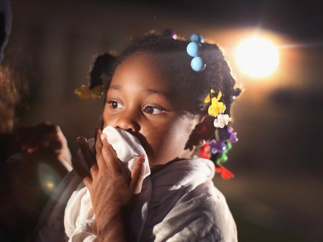 A child uses a rag to shield her face from tear gas being fired by police. Photo: Scott Olson/Getty Images/AFP
