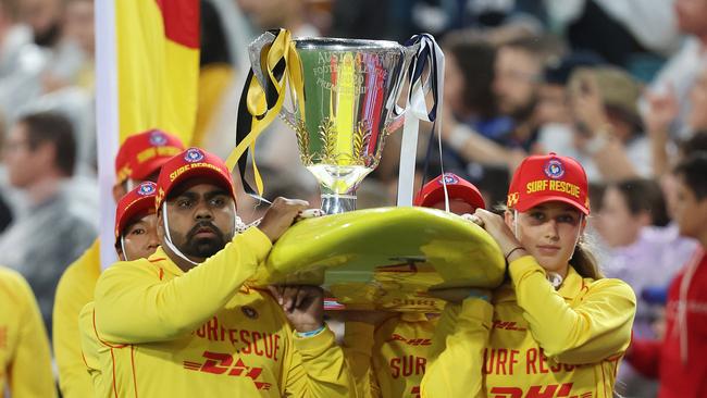 The premiership cup arrives on a surfboard. Picture: Michael Klein