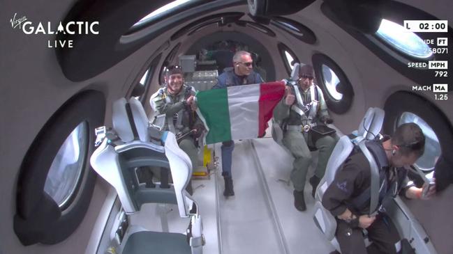 The Italian Air Force officers unfurl their nation’s flag at the point of space. Picture: AFP