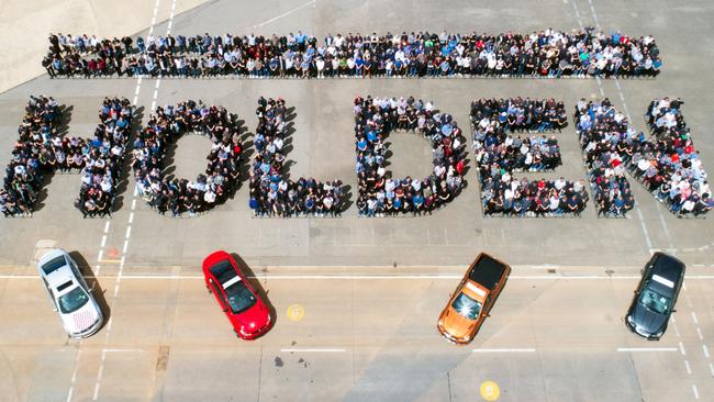 Holden workers at the Elizabeth plant in Adelaide yesterday with the final cars to roll off the assembly line.