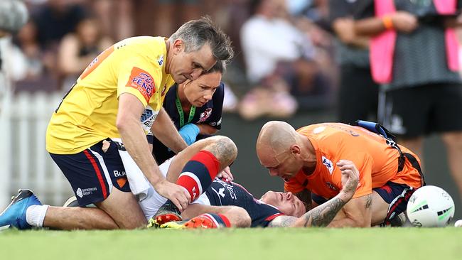 SYDNEY, AUSTRALIA - MARCH 13:  Jake Friend of the Roosters is attended to by team trainers after head knock during the round one NRL match between the Sydney Roosters and the Manly Sea Eagles at the Sydney Cricket Ground, on March 13, 2021, in Sydney, Australia. (Photo by Cameron Spencer/Getty Images)