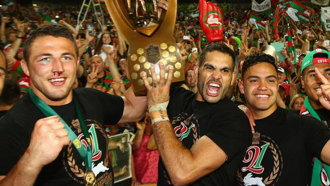 SYDNEY, AUSTRALIA - OCTOBER 05: Sam Burgess, Greg Inglis and Dylan Walker of the Rabbitohs pose with the trophy in front of the crowd after victory during the 2014 NRL Grand Final match between the South Sydney Rabbitohs and the Canterbury Bulldogs at ANZ Stadium on October 5, 2014 in Sydney, Australia. (Photo by Mark Kolbe/Getty Images)