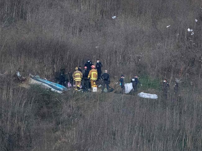 Los Angeles County Fire Department firefighters and coroner staff recover bodies from the scene of the helicopter crash. Picture: AFP