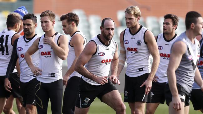 Matthew Broadbent, middle, stretches at training during his injury-interrupted season. Picture Sarah Reed