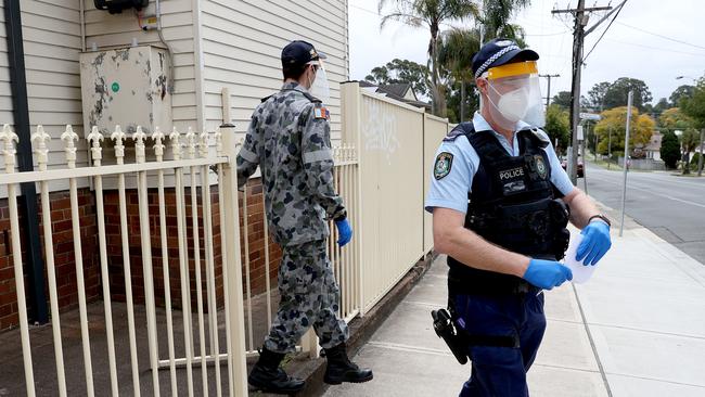 Australian Defence Force personnel and police check in on an address at Pendle Hill. Picture: Toby Zerna