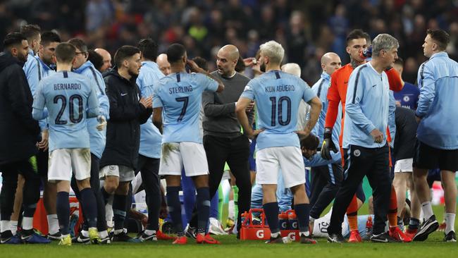 Manchester City manager Pep Guardiola, centre, talks to his player before the start of extra time. Picture: AP