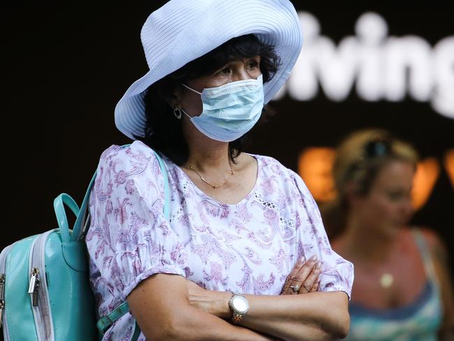 SYDNEY, AUSTRALIA - Newswire Photos JANUARY 03, 2022: A woman is seen wearing a face mask as she stops to watch the performer entertain the crowds shopping in Pitt Street Mall in the CBD in Sydney as Covid continues with very few people seen wearing face masks. Picture: NCA Newswire / Gaye Gerard