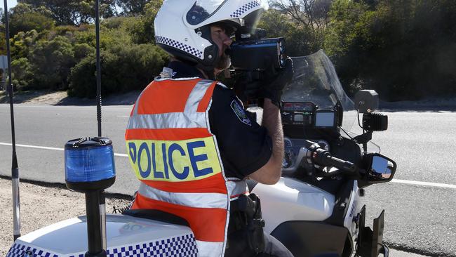 A SAPOL officer uses a laser gun to detect speeding drivers. Picture: Simon Cross