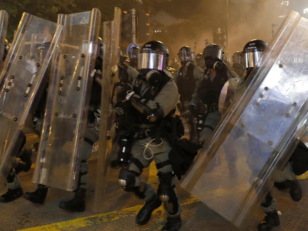 Riot police in protective gear run forward during a confrontation with protesters in Hong Kong. Picture: AP