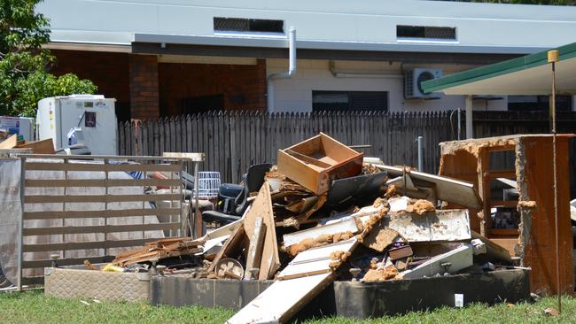 Streets in Machans Beach are piled high with wrecked furniture, whitegoods, mattresses and household contents as residents sort through what little is left. Picture: Bronwyn Farr