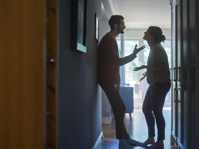 Young Couple Arguing and Fighting. Domestic Violence Scene of Emotional abuse, Stressed Woman and aggressive Man Having Almost Violent Argument in a Dark Claustrophobic Hallway of Apartment.