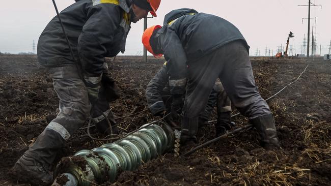 Workers repair high-voltage power lines cut by recent missile strikes near Odessa. Picture: AFP