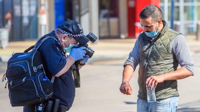 Police photograph the arm of a cab driver whose cab was attacked. Picture: Jay Town