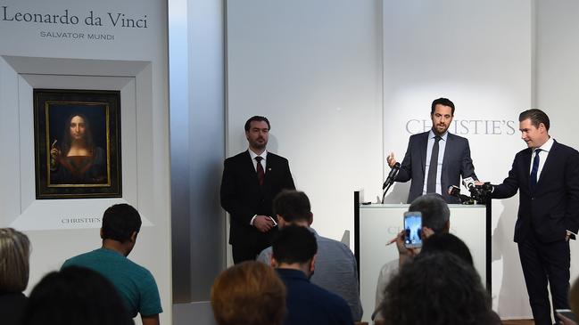 Loic Gouzer, centre, then head of contemporary art at Christie’s with Leonardo da Vinci's Salvator Mundi. Picture: Getty Images.