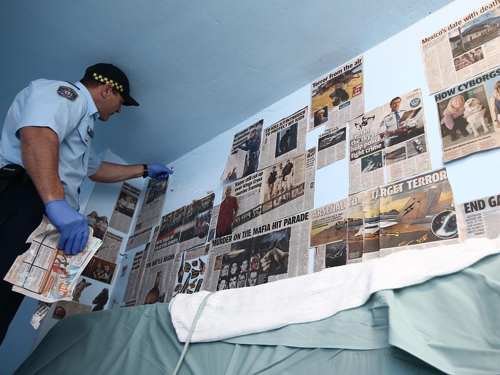 Terror-related material being taken down from the wall of an an inmate’s cell at Long Bay Jail. Picture: Tim Hunter