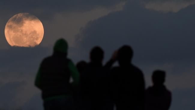 A crowd watches a supermoon from Bald Hill south of Sydney. The next full moon will hit the skies of Sydney on September 18. Picture: AAP Image/Dean Lewins