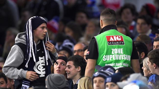 Security officers remove a spectator during the AFL match between Carlton and the Western Bulldogs at Marvel Stadium on Saturday. Picture: Getty Images