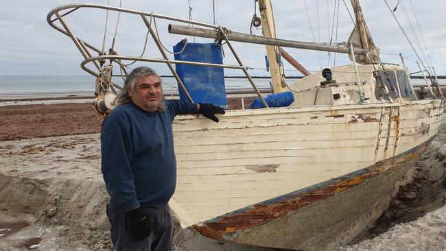 Novice sailor Claude Evans with his stranded yacht at North Haven. Picture: Colin James