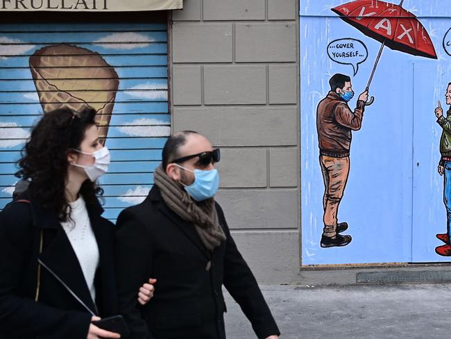 Masked Italians walk through the streets of Milan. COVID restrictions in Italy could be extended by another month. Picture: AFP