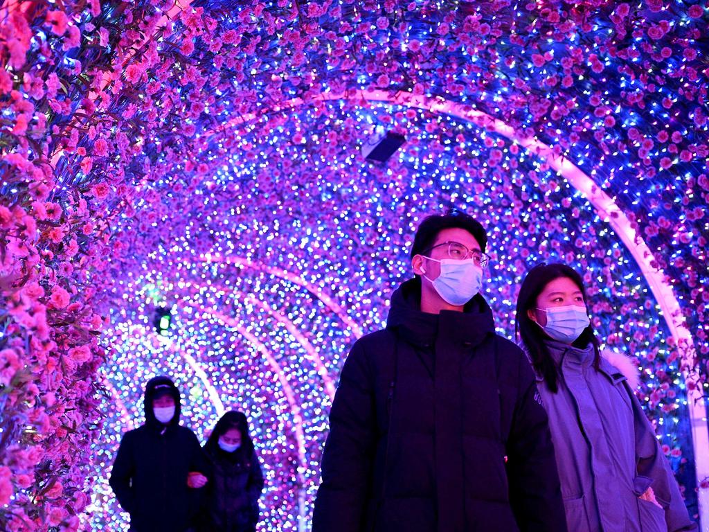 People wearing face masks walk at a mall in Beijing on December 21, 2020. Picture: Noel Celis/AFP