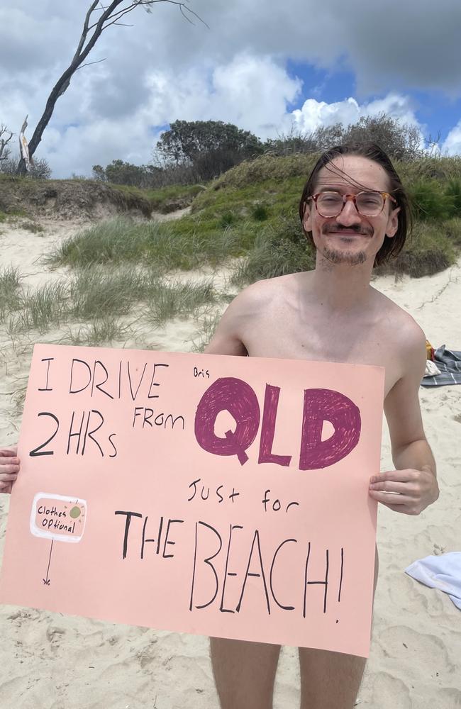 Eddie Davey, 30, proudly holding his sign of protest. He says becoming a naturist changed his life. Picture: Sam Stolz