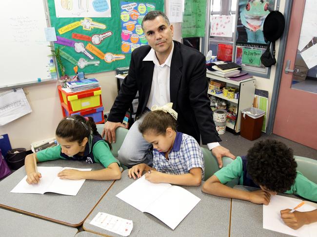 Dr Chris Sarra, executive director of the Indigenous Education Leadership Institute with students (L-R) Eliza (8), Talia (8) and Ezra (10) in their classroom at Tullawong State School, north of Brisbane.