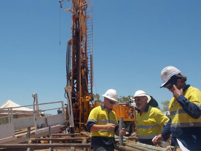 Armour Energy geologists inspecting a core taken at Lamont Pass 3 in the Northern Territory. Drill rig in the background. Picture taken october/november 2013. SUPPLIED. NTBR