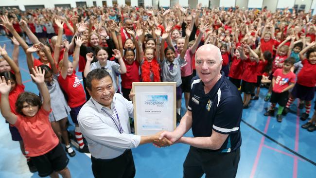 Hank Lewerissa is presented with a certificate to mark his near 40 years of service by Executive Principal Noel Rawlins at Upper Coomera State College. Picture: Richard Gosling.