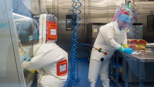 Workers next to a cage with mice, right, in 2017 inside the P4 disease-research laboratory in Wuhan, capital of China's Hubei province, when it was in a trial stage before its operations formally began about the beginning of 2018. A P4 lab is one accredited at biosafety level IV, with secure handling of waste and adequate staff protection against pathogens. Picture: AFP