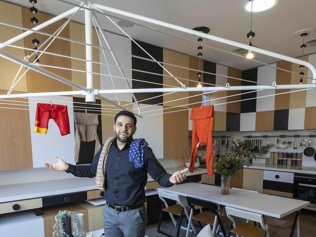 Bizarre Yarraville home for sale. Estate agent Huss Saad inside the home with the functioning Hills Hoist chandelier. Picture by Wayne Taylor