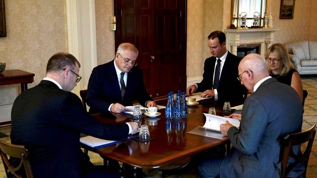 Mr Morrison (2nd L) is seen attending an executive council meeting with the Governor General David Hurley (R) to sign off on sanctions imposed on Russia (Photo by Adam Taylor / PRIME MINISTER OFFICE AUSTRALIA / AFP)