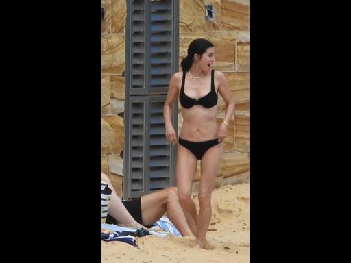 Courteney Cox wears a black bikini while swimming in Sydney