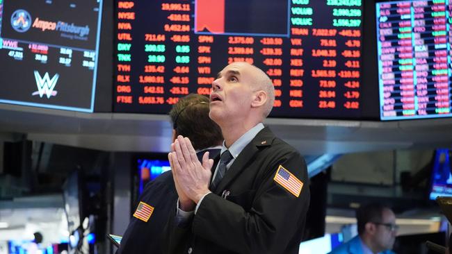 Traders work on the floor at the opening bell of the Dow Industrial Average at the New York Stock Exchange on March 18, 2020 in New York. - Wall Street stocks resumed their downward slide early Wednesday as the economic toll mounts from the rapid near-shutdown of key industrial and services sectors.About 15 minutes into trading, the Dow Jones Industrial Average stood at 20,040.66, down around 1,200 points or 5.6 percent. (Photo by Bryan R. Smith / AFP)